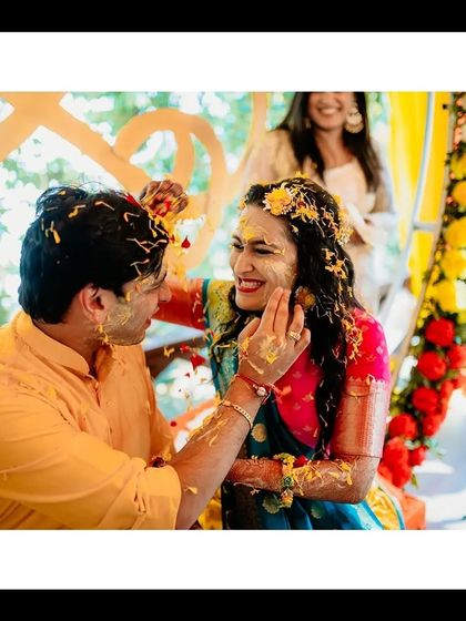 A playful moment between the bride and groom as they apply Haldi to each other, their faces lit up with joy.