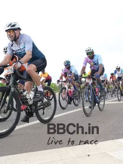 The masters peloton, a large group of experienced racers, rides in formation.