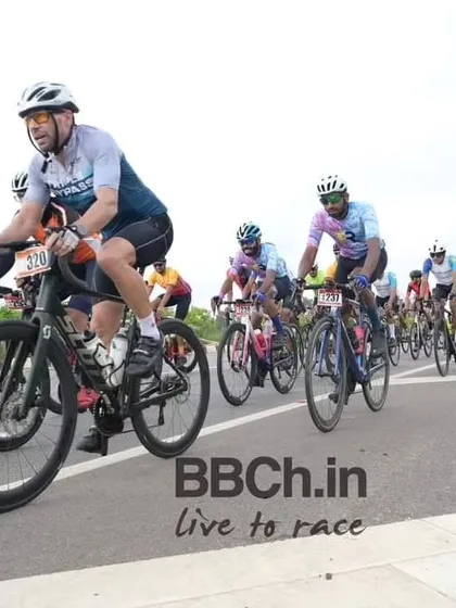 The masters peloton, a large group of experienced racers, rides in formation.