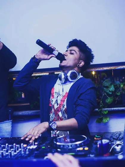 A candid photo of me on the mic while mixing on my Pioneer decks. This captures a typical moment where I'm blending tracks and engaging with the audience simultaneously.