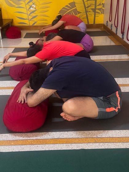 Part of a de-stress sequence: Balasana (Child's Pose) with bolster support. This gentle forward bend encourages introspection and surrender, calming the mind.