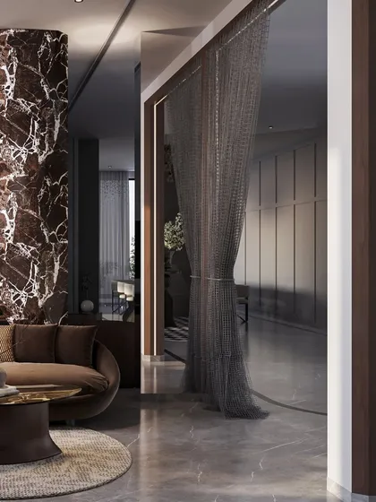 A metal chain curtain offers a unique, semi-transparent partition, adding a touch of industrial glamour. This detail separates spaces while allowing light and views to pass through, contributing to the home's layered and luxurious feel.