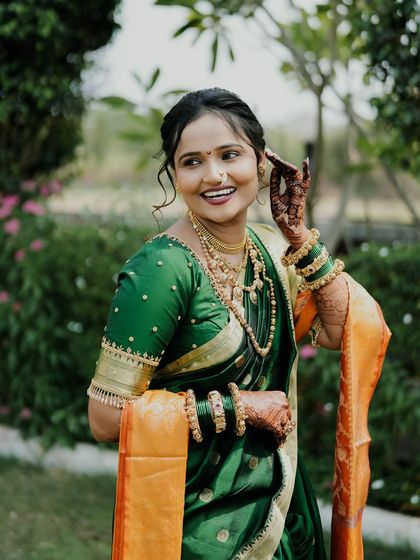 A joyful bride on her wedding day, her smile is as bright as her beautiful mehendi.