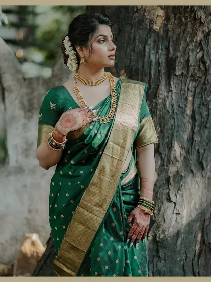 An elegant three-quarter portrait of the bride in her beautiful green Maharashtrian saree. The natural light and classic pose highlight her grace and poise.