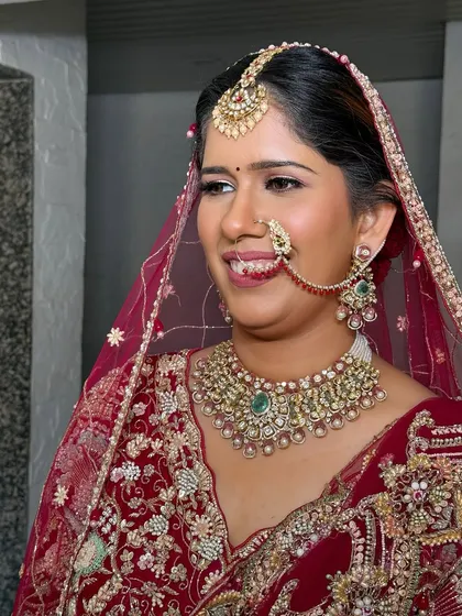 A side view showcasing the elegant silhouette of the bridal updo. This angle shows how the hair is styled to support the weight of the dupatta and jewelry.