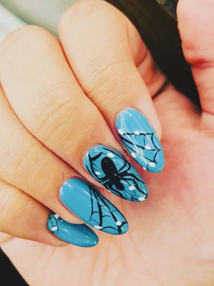 A spooky and stylish look perfect for Halloween. I used a bright teal base and hand-painted a black spider on one nail and intricate webs on the others.