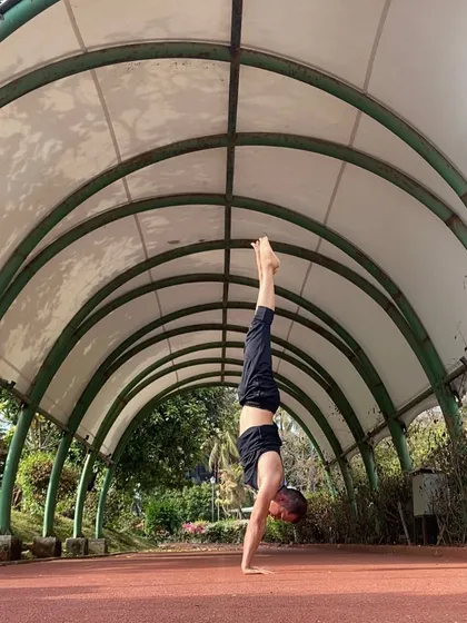 Finding balance in a handstand, or Adho Mukha Vrksasana, under this arched walkway. Inversions like this challenge your perspective and build immense focus and upper body strength. It’s a reminder that with practice, we can find stability even when the world is upside down.