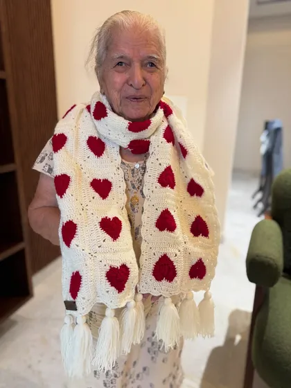 Wrap yourself in love with our signature heart muffler. Dadi is showcasing the classic white and red version here, complete with playful tassels. It’s a simple, heartfelt design that adds a touch of handmade charm to any outfit.