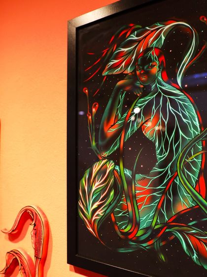 A close-up shot of my 'Glow in the Dark' illustration, framed and exhibited. The lighting highlights the rich colors and details of the archival print.