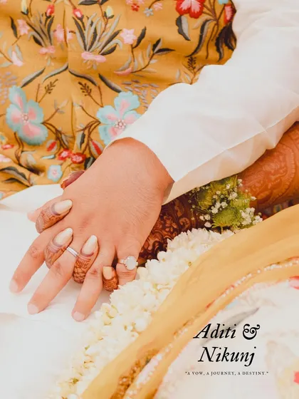 A close-up of the couple's hands, showcasing the bride's henna and their rings. This detail shot, with their names, tells a story of their union.