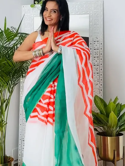 This tricolor saree with saffron and green stripes is a classic and elegant choice. I'm showing it here with a respectful 'namaste' pose.