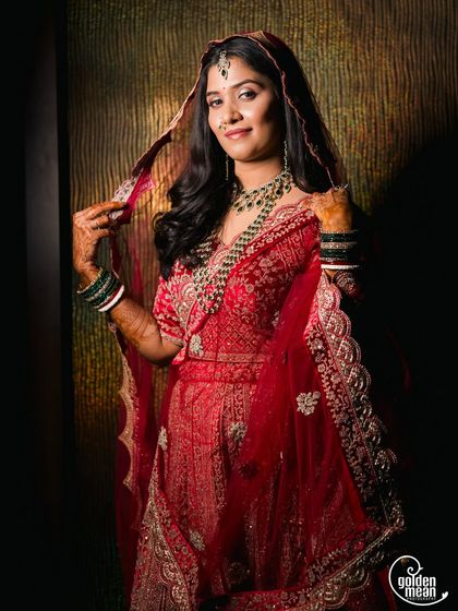 A stunning bridal portrait. The bride looks regal in her red lehenga and beautiful jewelry.