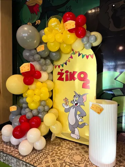 A classic Tom and Jerry theme for a 2nd birthday, with character cutouts and a balloon arrangement in red, yellow, and grey.
