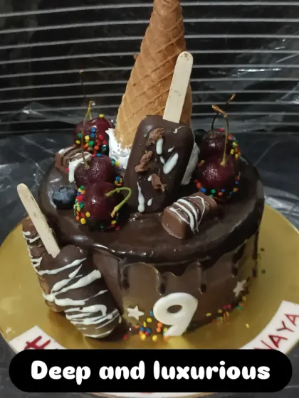 An overloaded chocolate drip cake. This indulgent creation is topped with mini cakesicles, an ice cream cone, fresh cherries, and colorful sprinkles.