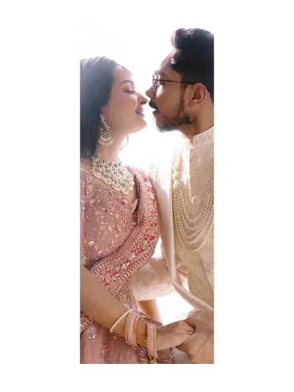 A vertical, intimate portrait of a couple, their faces close, captured in a moment of quiet affection.