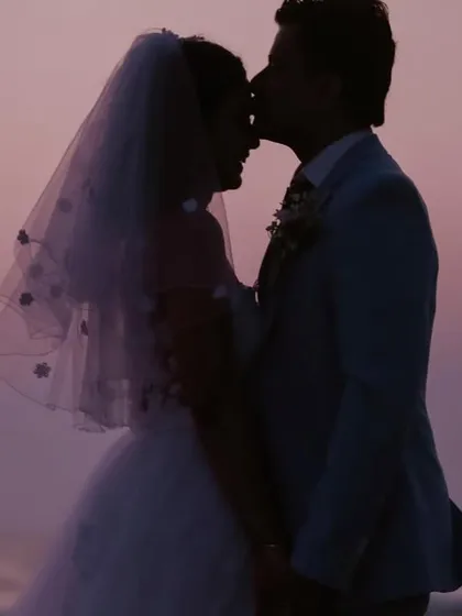 A perfect end to a perfect day. We use the sunset to create romantic, artistic silhouettes like this one, capturing a timeless kiss against the evening sky for this beautiful Catholic beach wedding.