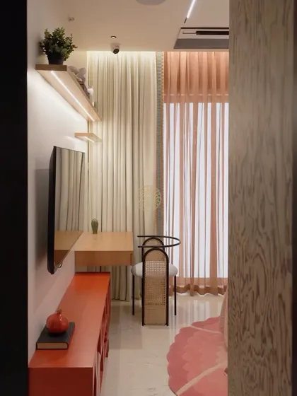 A view of the kids' bedroom, showing the narrow layout and how we maximized the space with a floating desk and open shelving.