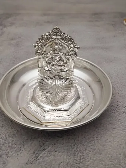 A German silver diya with a Lakshmi backplate, resting on a small plate. A simple and complete set for daily worship.