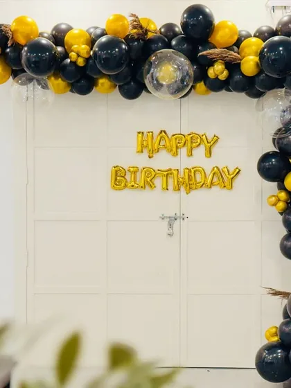 The full view of the black and gold birthday decoration. This setup instantly transforms a simple doorway into a stunning photo backdrop for the celebration.