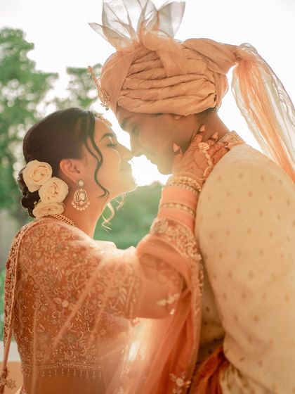 A sun-kissed moment from Anu and Omkar's first look. Her makeup is soft, glowing, and perfect for a day wedding.