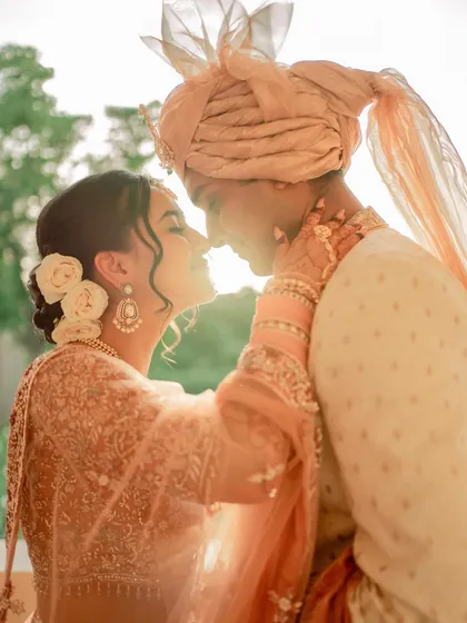A sun-kissed moment from Anu and Omkar's first look. Her makeup is soft, glowing, and perfect for a day wedding.