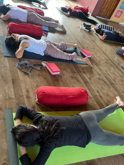 Students in a supported prone twist, using bolsters to help them relax into this gentle but deep stretch for the spine and hips.