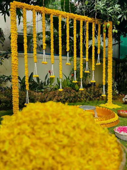 A close-up shot of the Haldi ceremony setup, showing the baskets filled with fresh marigold petals ready for the celebration.