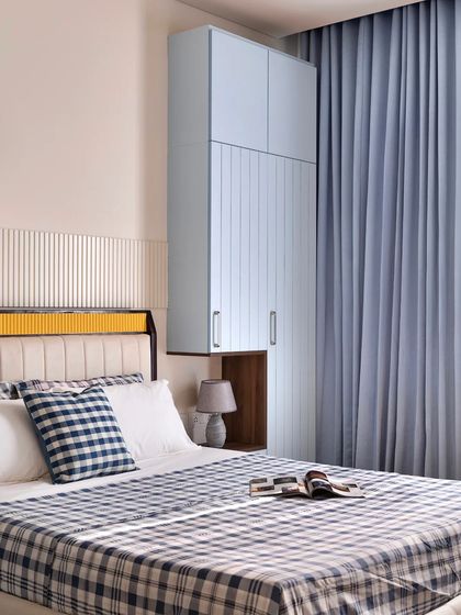 For the father's bedroom, I used a powder blue theme for a calming effect. The floating wardrobe includes a built-in nightstand, a smart solution for a compact space.