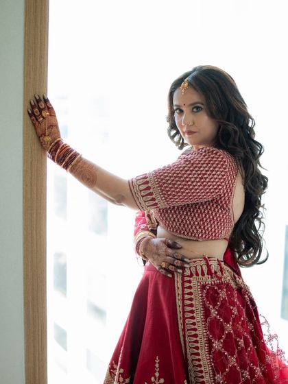 The bride posing by the window, showcasing her rich henna stain. My goal is always to provide a color that looks stunning in wedding photos.
