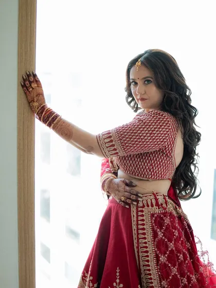The bride posing by the window, showcasing her rich henna stain. My goal is always to provide a color that looks stunning in wedding photos.