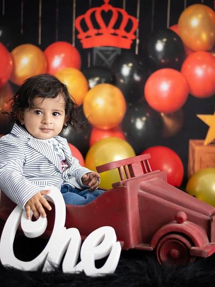 "Hey, I am ONE now." This king-themed first birthday shoot uses a bold black, red, and gold color scheme for a dramatic and fun look.