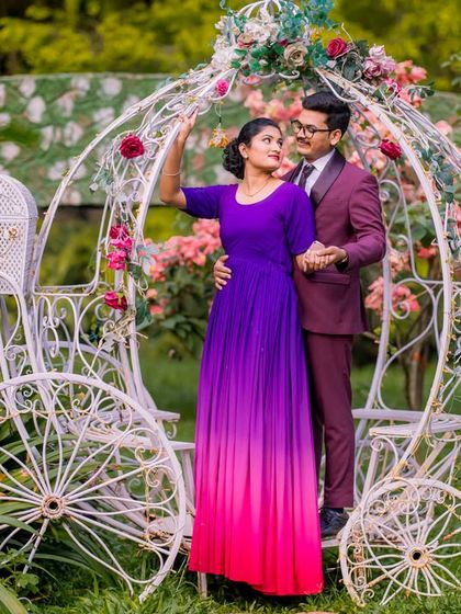 A sweet couple poses by the Cinderella carriage, a classic choice for a romantic pre-wedding shoot.