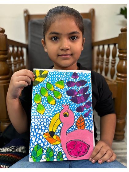 A first-grade student displays her beautiful drawing of a pink toucan, using patterns and textures to create a lively background. We learn how to make our subjects stand out with creative details.