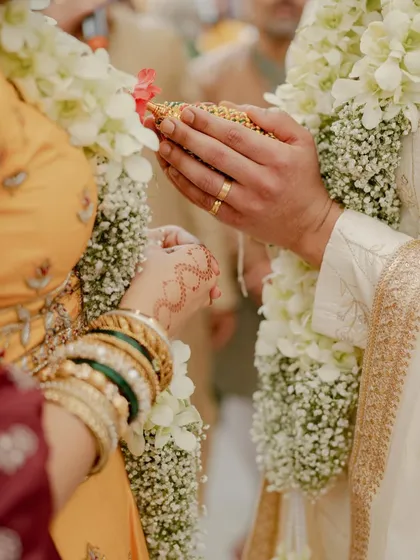 A close-up on the hands and rituals, showcasing the intricate details of the ceremony and the beautiful henna on the bride's hands.