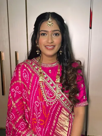 A close-up of the client's glowing makeup and beautiful smile.