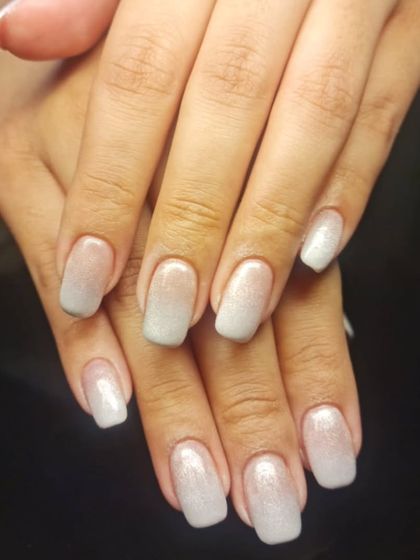 A subtle and chic white glitter ombre on square-shaped nails, perfect for an elegant, understated sparkle.