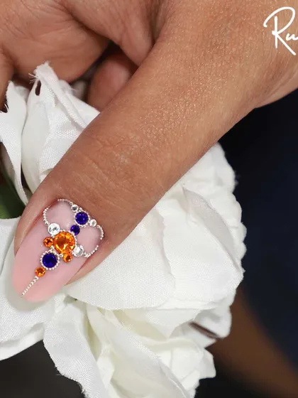 The same multi-colored crystal design held against a white flower.