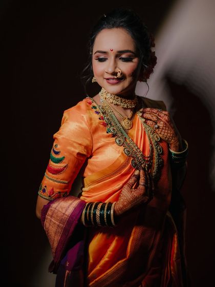 The bride gently touching her necklace, a simple gesture that draws attention to the beautiful jewelry and her serene expression.