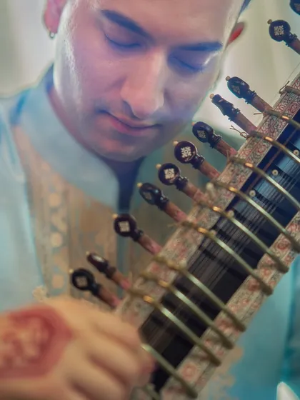 A close-up look at the details. My hands, adorned with henna featuring a Ganesha design, and the intricate craftsmanship of the sitar, handmade by my father. Every element of the performance is a form of expression and devotion.
