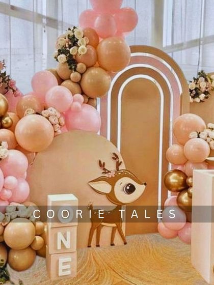 A sweet and gentle woodland theme for a first birthday. This setup features an adorable deer cutout, "ONE" blocks, and a soft, neutral color palette of pink and tan balloons for a heartwarming celebration.