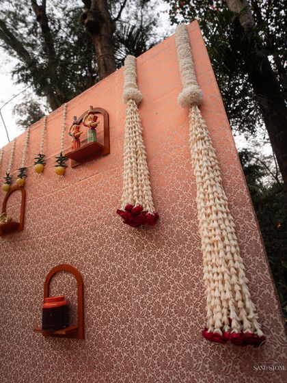 A closer look at the upcycled saree backdrop, showing the texture of the fabric and the elegant tuberose garlands that add a traditional floral element to the design.