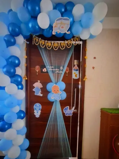An elaborate entrance decoration to welcome a new baby boy. I created a full balloon arch around the door and added blue netting and cute baby-themed cutouts.