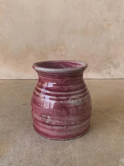 A small vase with a beautiful, streaky red glaze. The imperfections in the glaze make it even more interesting.