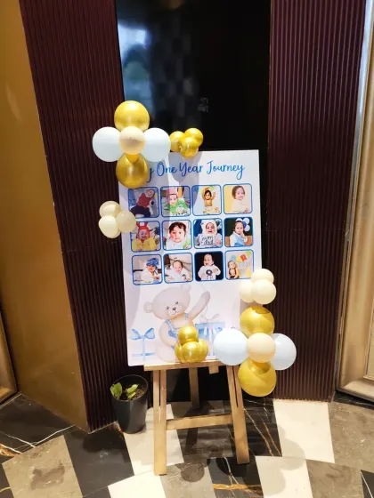 A 'One Year Journey' photo board for a first birthday. This is a great way to display memories from the baby's first year, framed with a simple balloon accent.