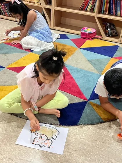 Children of all ages enjoy our craft sessions. Here, they are spread out on the floor, comfortably painting their Ganesha crafts.