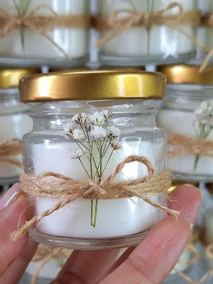 For a rustic and delicate look, we can add a sprig of dried baby's breath and a jute bow to our mini candles.