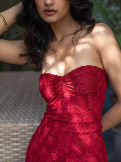 A close-up on a vibrant red lace top. The focus on the texture and color makes this a striking and desirable image for a fashion brand.