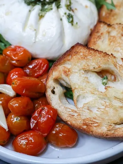 A beautiful plate of our fresh burrata, served with roasted cherry tomatoes and toasted sourdough slices for dipping.