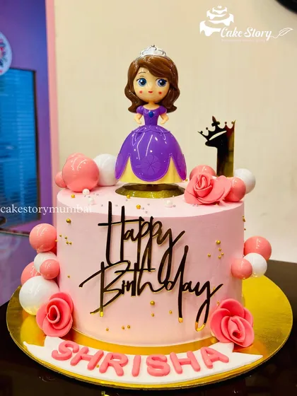 A pretty pink princess cake for a first birthday. This design features a Sofia the First topper, pink roses, and balloon decorations.