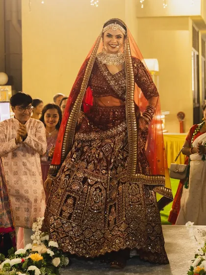 The bride's grand entrance. Her magnificent lehenga and radiant makeup ensure all eyes are on her as she walks down the aisle.
